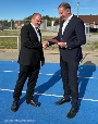 Der Parlamentarische Staatssekretär für Vorpommern und das östliche Mecklenburg Heiko Miraß (r.) übergibt auf der Sport- und Trainingsanlage 