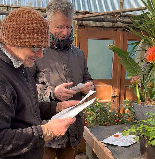Zoo-Gärtner und Zoo-Direktor beim Studium der Pflanzanleitung